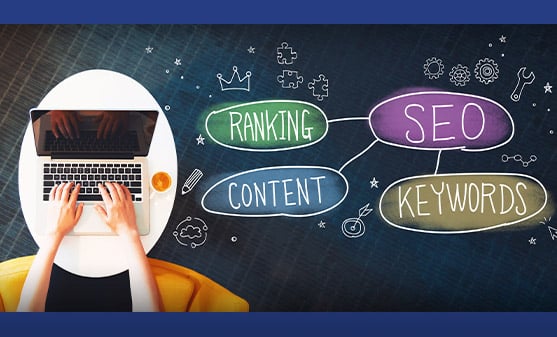 Laptop with word bubbles of ranking, content, SEO, keywords