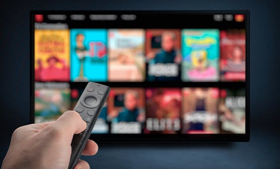 Hand holding a remote pointed at screen